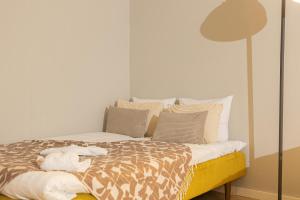 a bedroom with a bed with pillows and a lamp at Santa's City Suite by Book Lapland in Rovaniemi