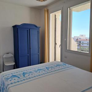 a bedroom with a blue cabinet and a window at Appartamento vista mare in Santa Teresa Gallura