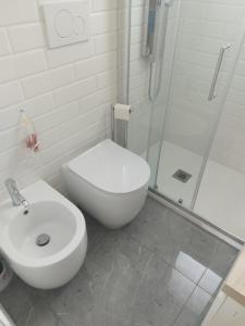 a white bathroom with a toilet and a shower at Appartamento vista mare in Santa Teresa Gallura +22 photos