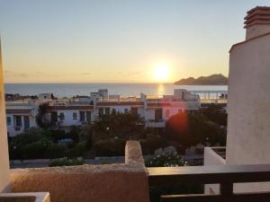 a view of the sunset from the balcony of a building at Appartamento vista mare in Santa Teresa Gallura