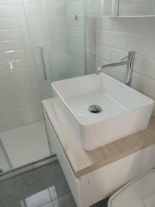 a white bathroom with a sink and a shower at Appartamento vista mare in Santa Teresa Gallura