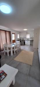 a living room with a table and a kitchen at De Rust Karoo Cottages in De Rust