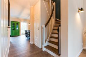 eine Treppe in einem Haus mit grüner Tür in der Unterkunft Schusterkate - [#96108] in Staberdorf