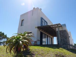 una casa blanca en una colina con una planta en El Vuelo, en Punta del Diablo