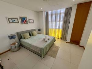 a bedroom with a bed and a large window at Superbe Duplex 2 Chambres La Croisette Grand Baie in Grand Baie