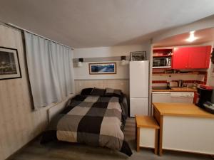 a small bedroom with a bed and a refrigerator at Résidence Digitale - 3 pièces pour 6 personnes - Piscine, sauna et Parking Privé in Plagne 1800