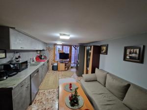 a living room with a couch and a table in a kitchen at Villa Popovi in Simitli