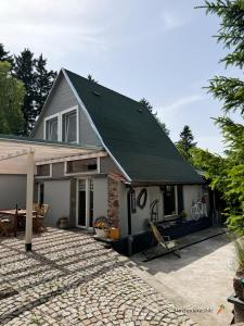 a house with a black roof and a driveway at Marchewkowe Pole in Sośnina