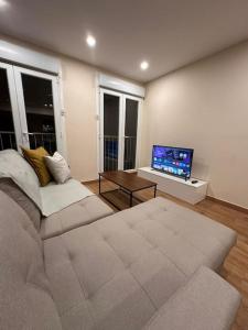 a living room with a couch and a flat screen tv at Zen Mayar House Toulouse centre in Toulouse