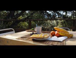 a table with a plate of food and fruit on it at Cabaña del árbol Lavagarural in Villanueva del Rosario +16 photos