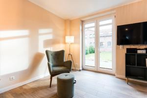 ein Wohnzimmer mit Sessel und Fernseher in der Unterkunft Backhaus 3 in Staberdorf