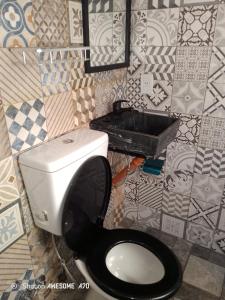 a bathroom with a black and white toilet and a sink at Lo de tina in Florencio Varela +9 photos