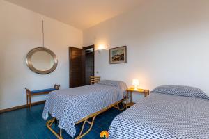 two beds in a room with a mirror at Villa Le Sirene on the beach in Fort Village +54 photos