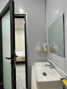 a bathroom with a sink and a mirror and a bed at Hà Linh Motel in Vung Tau +27 photos