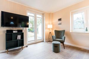 ein Wohnzimmer mit einem Flachbild-TV und einem Stuhl in der Unterkunft Backhaus 4 in Staberdorf