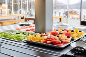 a buffet of fruits and vegetables on a table at Amenity Hotel & Resort Lipno in Lipno nad Vltavou