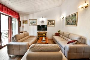 een woonkamer met twee banken en een tv bij Apartments Villa Herak in Poreč