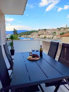 un tavolo con bicchieri di vino e una pizza su un balcone di House Povlja (3365) a Povlja