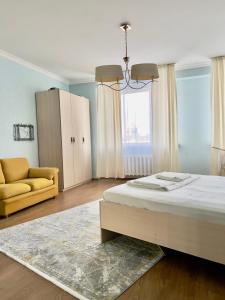 ein Schlafzimmer mit einem Bett, einer Couch und einem Kronleuchter in der Unterkunft 205 Очень теплая 3 комн квартира у Байтерека с 3 большими кроватями и раскладным диваном для 1-8 человек in Astana