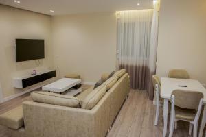 a living room with a couch and a table and a tv at Vollgaapartment2 in Durrës