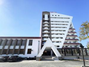 a large white building with a sculpture in front of it at Nafta Sanatorium in Naftalan
