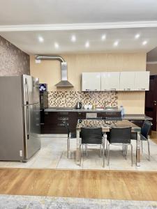 eine Küche mit Tisch und Stühlen und einem Kühlschrank in der Unterkunft 205 Очень теплая 3 комн квартира у Байтерека с 3 большими кроватями и раскладным диваном для 1-8 человек in Astana