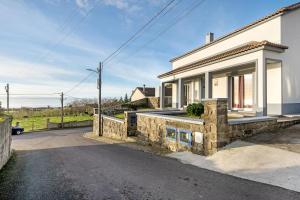 uma casa branca com uma parede de pedra em Cantinho do Sossego na Várzea
