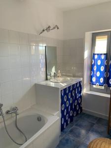 a bathroom with a bath tub and a sink at Duplex T3 climatisé centre terrasse parking payant in Manosque +13 photos