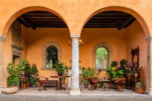 a courtyard with tables and potted plants in a building at Villa Alberici in Rome