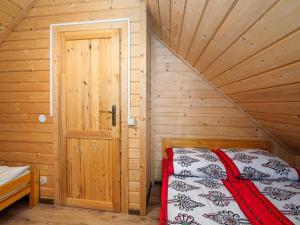 a bedroom with a bed in a wooden cabin at Chatki u Tadka - idealne dla rodzin i grupy znajomych - świetna lokalizacja, na przeciwko term Chochołowskich in Chochołów