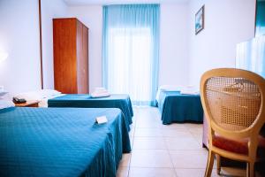 a hospital room with two beds and a chair at Magnolia Hotel Vieste in Vieste