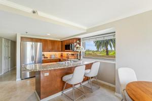a kitchen with a counter and two chairs and a table at Luana Waikiki Hotel & Suites in Honolulu