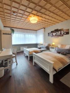 a bedroom with two beds and a table and a desk at Friendly Home - Villa Verde in Bornheim
