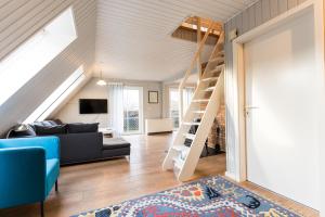 Una sala de estar con un sofá y una escalera. en Inselhaus OG, en Staberdorf