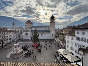 eine Gruppe von Menschen, die durch ein Gebäude mit einem Weihnachtsbaum laufen in der Unterkunft Attico sul Duomo in Trient
