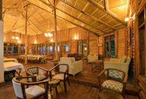 a large room with tables and chairs in a building at Orugano Bwindi Lodge in Kisoro