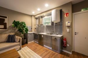 a kitchen with a sink and a couch in a room at VALERIA DREAMS-Mártires 3ºA - EL TUBO in Zaragoza