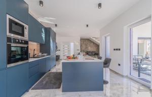 a kitchen with blue cabinets and a white counter top at Cozy Home In Labin With Sauna in Labin