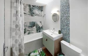 a bathroom with a sink and a toilet and a tub at Beautiful Apartment With Wifi in Pornic