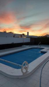 a swimming pool with a sunset in the background at Casa Jaime in Puerto del Carmen