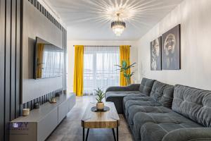 a living room with a gray couch and a table at Luxury Residences & Suites in Central Brasov at Coresi Mall in Braşov
