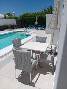 a table and chairs next to a swimming pool at Casa Jaime in Puerto del Carmen