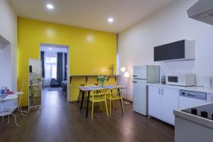 a kitchen with a table and a yellow wall at Masiarska Apartment 1 Best Adress In City Center Kosice in Košice
