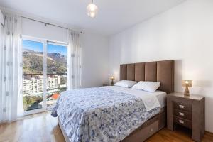 a bedroom with a large bed and a large window at Sunny Side Wellness Resort & Spa in Budva