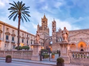 a building with a palm tree in front of it at Baia delle Sirene by Holiday World in Porticello