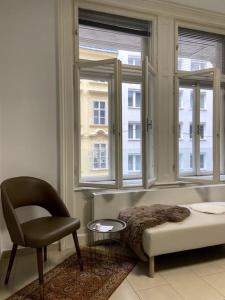 a living room with a chair and a window at Luxury Serviced 3-Bedroom Flat in Vienna's 1st District in Vienna