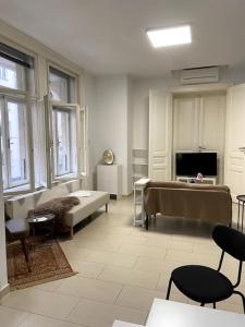 a living room with a bed and a tv at Luxury Serviced 3-Bedroom Flat in Vienna's 1st District in Vienna