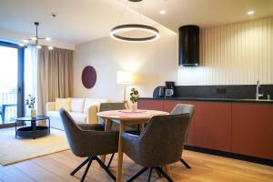 eine Küche und ein Wohnzimmer mit Tisch und Stühlen in der Unterkunft Loft Premium Apartments by Baltic Home in Świnoujście