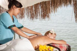 a woman giving a young girl a massage on the beach at Golden Age Hotel Yalıkavak Bodrum in Yalıkavak