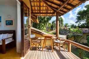a wooden deck with a table and chairs on it at Casa Baiana Pousada & Aconchego in Trancoso